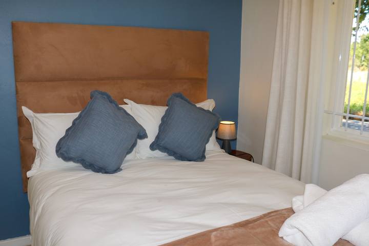 Bedroom with a blue feature wall and leather headboard