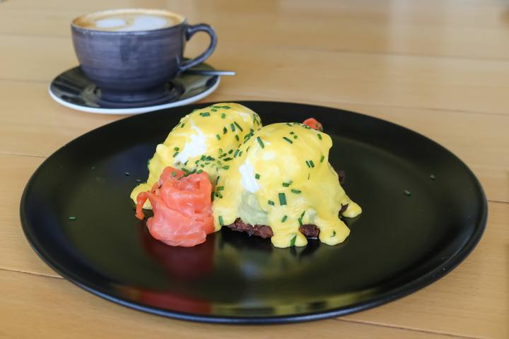 Eggs and coffee on a black plate