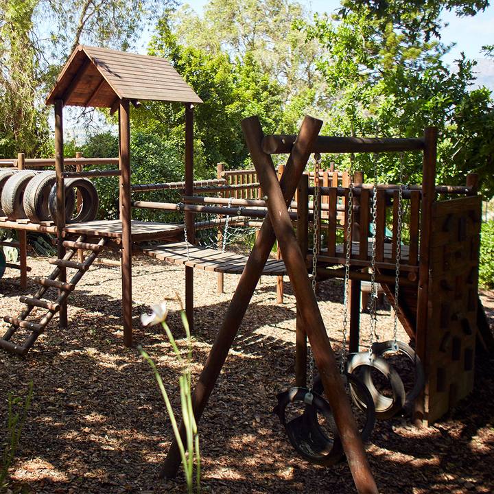 Children's play area with wooden swings and a climbing frame