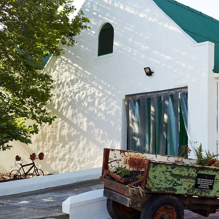 Whitewashed building and an old farm trailer in the sun