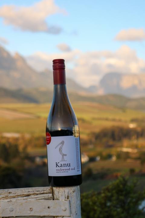 A bottle of Kanu wine against the mountains at golden hour