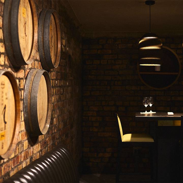 Oak barrels on the cellar wall beside pendant lights