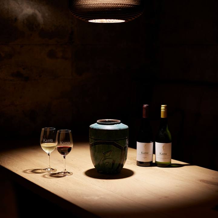 Two glasses and bottles on a spotlit table