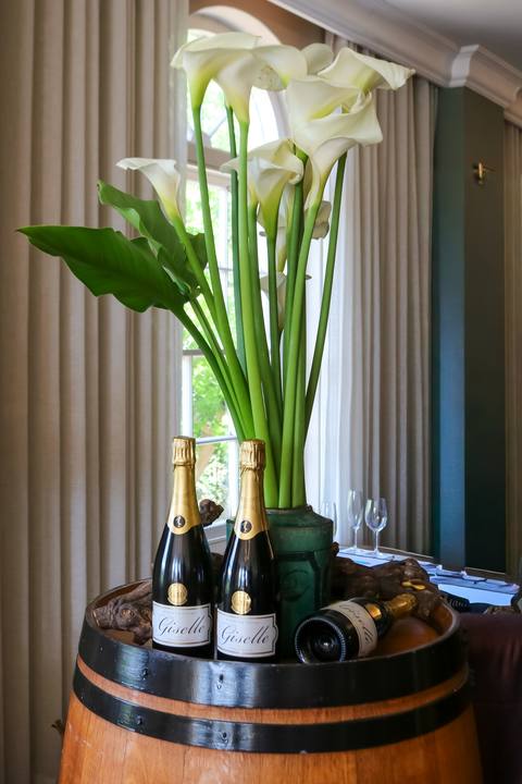 Calla lilies on a barrel with two bottles of wine