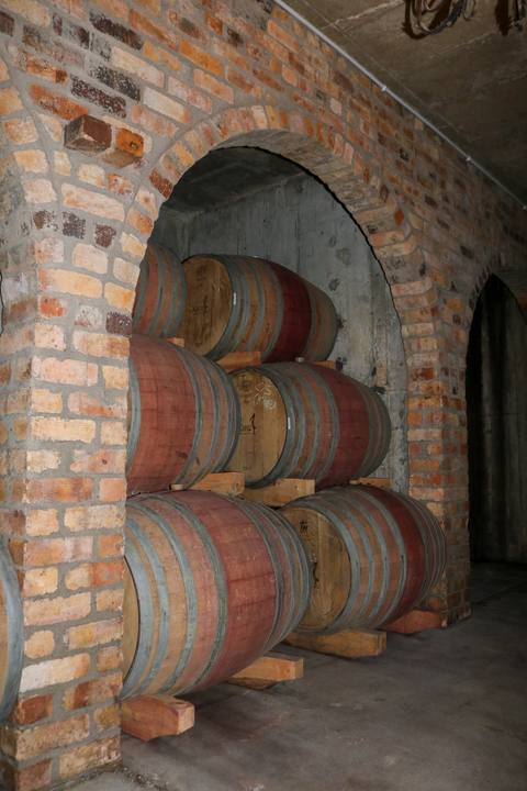 Barrels stacked inside a brick archway